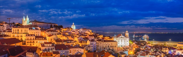 Panorama of Lisbon famous view from Miradouro de Santa Luzia tourist viewpoint over Alfama old city district at night. Lisbon