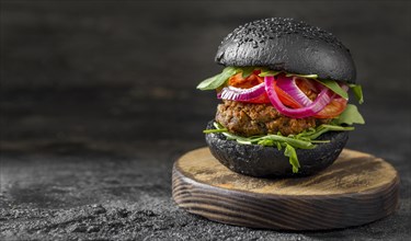 Front view veggie burger with black buns cutting board
