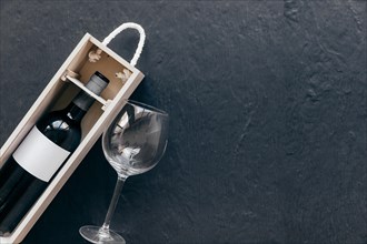 Empty glass near box with wine