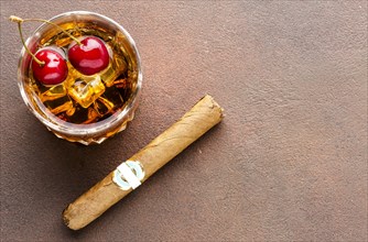 High angle whiskey rocks with cherries cigar with copy space