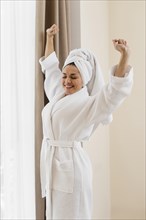 Woman wearing bathrobe hotel room