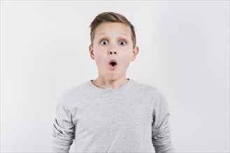 Shocked boy looking camera against gray background
