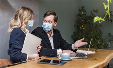 Business man woman talking about new project while wearing medical masks