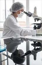 Medium shot researcher working with microscope