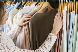 Woman choosing dress during shopping garments apparel
