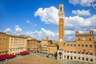 Spring clouds over the Piazza del Campo with the bell tower Torre del Mangia and the town hall Palazzo Pubblico