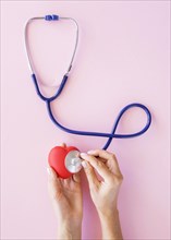 Top view hands checking heart with stethoscope