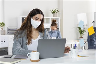 Medium shot woman working laptop