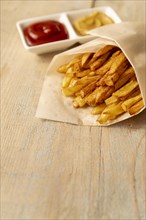 Close up french fries with wooden background