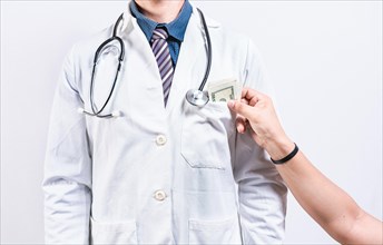 Medical bribery concept. Hand of person bribing doctor