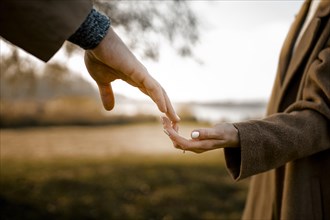 Close up couple holding hands outdoors