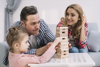 Family playing with block wooden game table living room