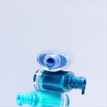 Close up blue shades nail polish with stacked open bottle