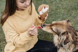 Woman giving ice cream her dog