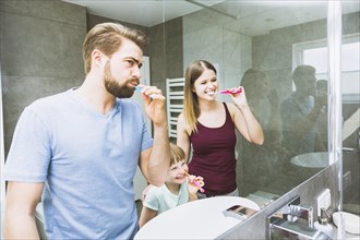 Cheerful family brushing teeth