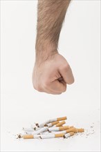 Man s hand giving punch broken cigarettes isolated white backdrop