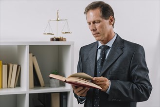 Mature male reading legal book courtroom