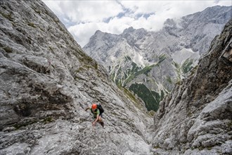 Mountaineer climbing in steep rocky terrain on the way to Waxenstein