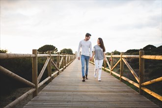 Loving couple walking bridge by hand