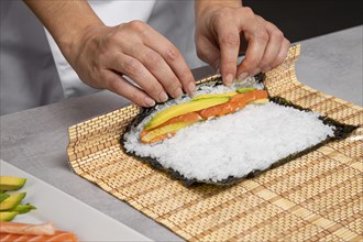 Close up hands preparing tasty sushi