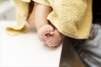 Close up baby legs with yellow towel