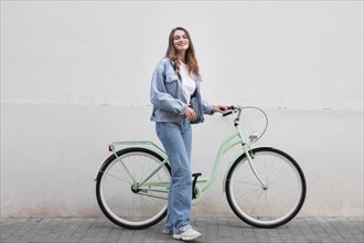 Woman posing while holding her bike outdoors city
