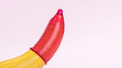 Banana with red condom copy space