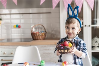 Portrait little boy holding basket with easter eggs