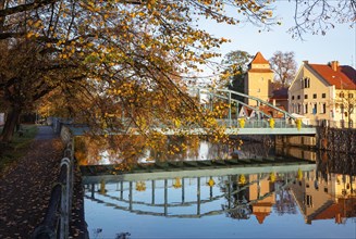 Autumnal coloured trees with iron bridge over the river Maltsch with the city wall of the historical old town of Ceske Budejovice