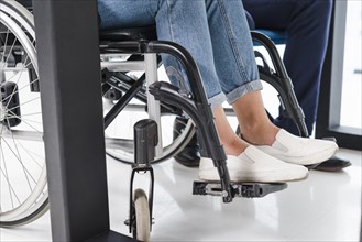 Disabled woman s feet wheel chair white floor