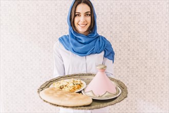 Woman holding plate arab food