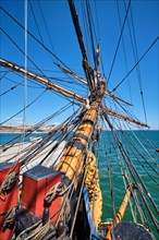 Bowspirit of old wooden sail ship with a lot of gear cordage rope