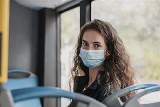 Woman with curly hair wearing medical mask bus