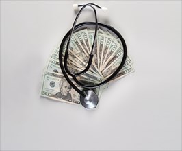 Stethoscope on one dollar bills isolated with copy space. Medical stethoscope on twenty dollar bills isolated