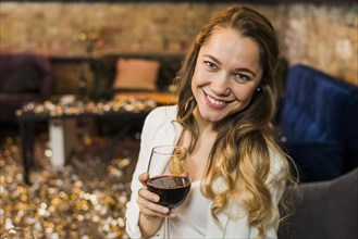 Young woman holding glass red wine bar