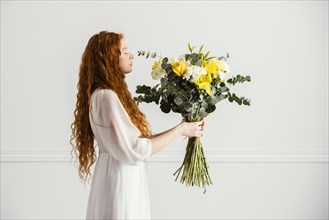 Side view woman posing with beautiful bouquet spring flowers