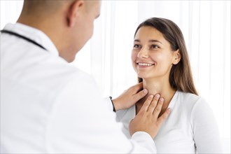 Back view doctor examining woman neck