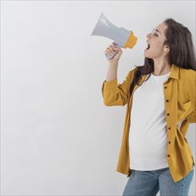 Side view pregnant woman shouting megaphone