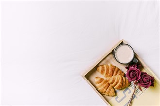 Tray with croissants roses bed