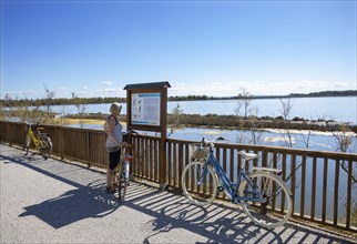 Cyclist at an information board along the cycle path of the Valle Cavanata nature reserve