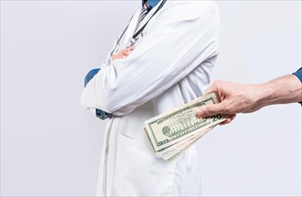 Hand of person bribing doctor. Hands putting money in doctor pocket