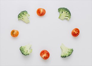 Arranged halved broccoli cherry tomatoes circular frame isolated white background