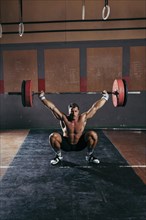 Gym concept with strong man lifting barbell