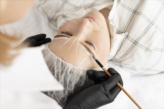 Woman getting eyebrow treatment beauty salon
