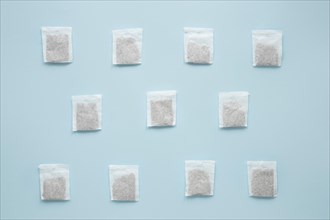 Overhead view teabags arranged against blue background