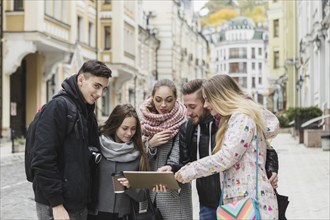 Cheerful tourists with tablet street
