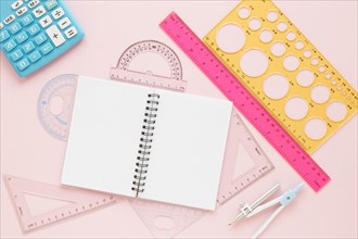 Math rulers supplies with open empty notebook flat lay