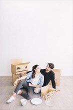 Couple leaning against moving boxes