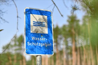 Blue sign with German text 'Water protection area' with bullet holes
