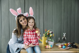 Young woman hugging daughter bunny ears